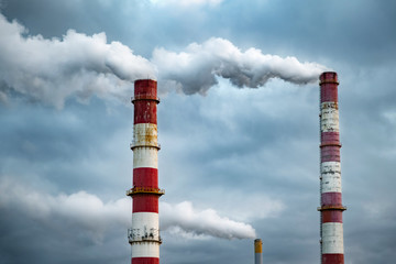 Dark toxic smoke clouds coming out of factory chimney. Air pollution and global warming caused by...