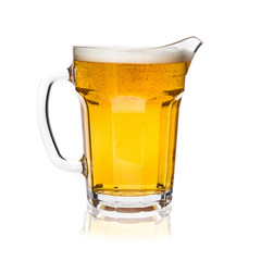 Glass jug of light beer with foam isolated on white background.