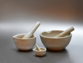 White porcelain mortar with pestle handle stock images. Set of mortar and pestle. Three white porcelain mortar and pestle of different sizes