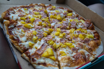 Pizza Hawaii in einer Schachtel in schräger Aufnahme