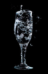 Water with splashes in a glass on a black background