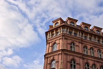 Fototapeta na wymiar Old red bohemian building with a cloudy sky background (Prague, Czech Republic, Europe)