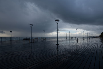 Lanterns on the embankment after rain and cloudy sky