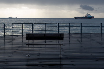 Promenade benches after rain and cloudy sky