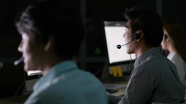 Operator man work together with his team to support the customer at night.