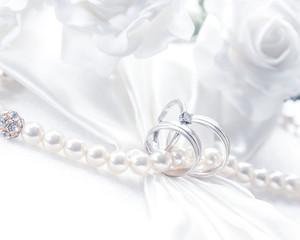 Diamonds and pearls, wedding rings entwined with pearls