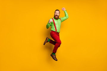Fototapeta na wymiar Full size photo of ecstatic cheerful man win discount lottery feel rejoice jump raise fists scream yeah wear good look trousers isolated over shine bright color background