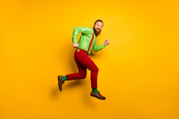 Fototapeta na wymiar Full size photo of cheerful irish man jump run after discount wear good look clothing suspendsers trousers shoes isolated over bright color background
