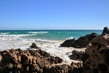 Beautiful Atlantic ocean shore with rocks and strong waves. Seaside scenery of south-east coast of Fuerteventura, Canary Islands, Spain