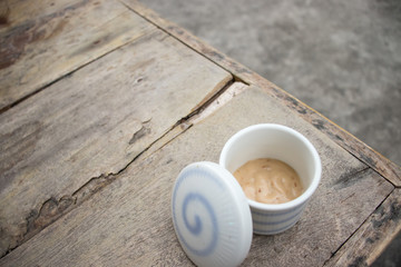 cup of salad dressing on wooden table