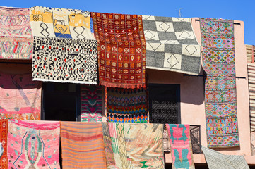Moroccoan colorful carpets and blankets, cushions hanging at the souks and market places in Morocco