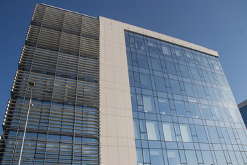 Obraz premium Urban metropolis modern architecture. Exterior with glass walls, reflecting surrounding buildings. Brand new buildings for business and office purposes