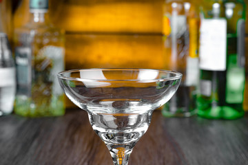 Empty winei glass on background of bottles with alcohol drinks
