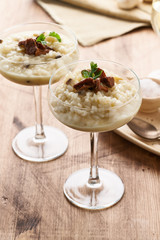 Risotto with mushrooms in wine glass. Unconventional unusual serving. Side view, vertical