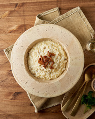 Risoto with chanterelle mushrooms in large plate. Traditional italian dish. Wooden old table