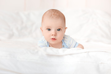 Portrait of cute little baby lying on bed