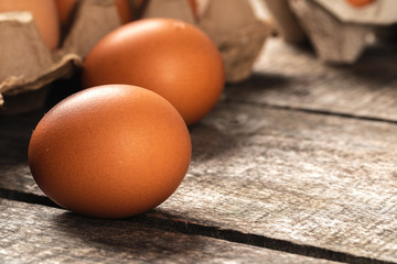 Chicken eggs in box on wooden table.