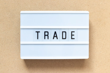 White lightbox with word trade on wood background