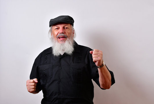 Old man  in a fighting stance and smiling... .Mature gentleman with a newsboy cap and black guayabera shirt and long white beard..