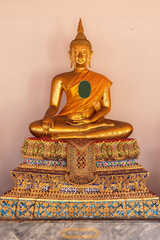 Golden Buddha statue  on white wall at Bangkok,Thailand