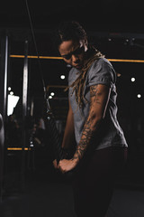 Fototapeta na wymiar young african american woman with tattoo exercising in gym