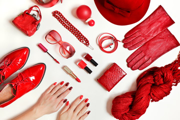 A diverse collection of clothing and accessories in red on a white background.Fashionable decorative cosmetics and nail art on women's hands from light red to dark nail Polish.