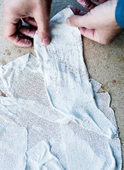 man working with fabric soaked in wet plaster