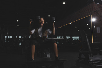 tattooed african american girl working out on gym machine