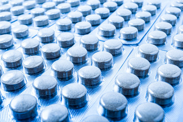 A row of medicine pills close-up in blister packs. Sealed medicaments produced at a pharmaceutical factory from natural herbal raw materials.