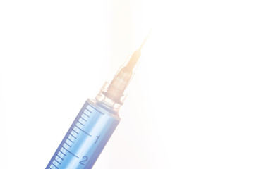 syringe with medicine in bright light. cure for illness concept.