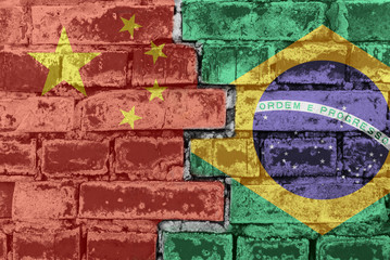 China and Brazil flag against a brick wall