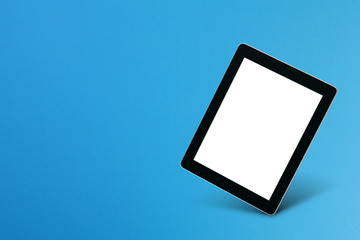 Modern digital tablet isolated on blue background with copy space