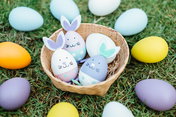 Easter bunny ornaments in nest and Easter Eggs on lawn grass, Happy Easter concept.Close up