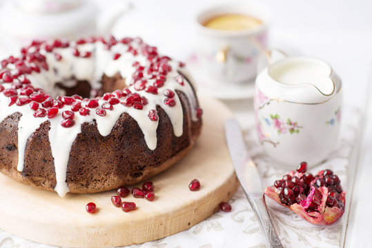 chocolate cake with pomegranate on a white table, a cozy breakfast, English tea party, chocolate dessert, a delicious cake with pomegranate, a photo of sweet food with free space for text