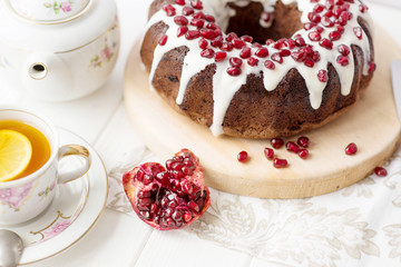 chocolate cake with pomegranate on a white table, a cozy breakfast, English tea party, chocolate dessert, a delicious cake with pomegranate, a photo of sweet food with free space for text