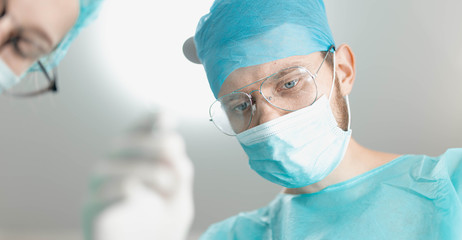 surgeon doctor with assistant student girl in the operating room. first-person view of the patient.