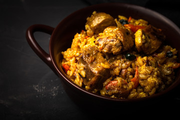 Large portion of pilaf in a clay dish. Delicious uzbek homemade meal. Toned