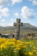 The summer view of old Celtic cross on the grave in Scotland