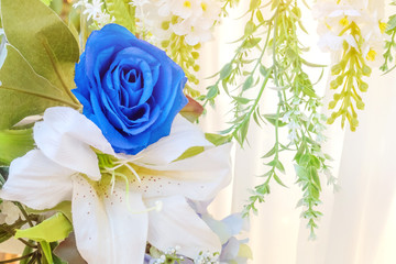 Artificial blue and white flowers decorate the arch as the backdrop in the wedding ceremony. Flowers background. Selective focus.