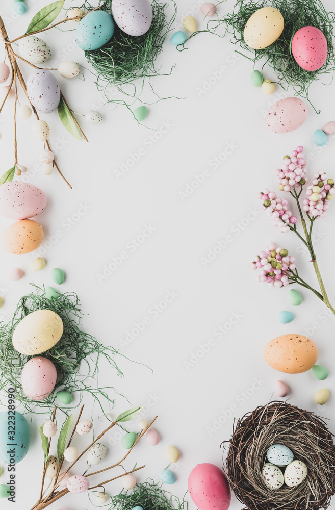 Wall mural Top down view of an Easter border flat lay including robin's eggs, chocolate eggs and nests in desaturated colours.