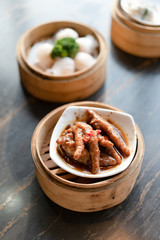 tradition Chinese prawn dumplings and chicken feet placed in a bamboo steamer