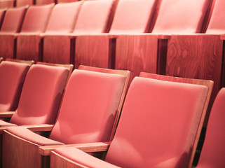 Selective focus of Empty rows of armchairs in hall. Empty pink chairs in conference hall or theater.