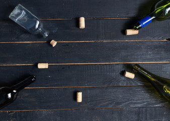 Empty bottles with corks on black wooden background