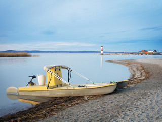 Fototapeta premium Boat and lighthouse at podesdorf at neusiedlersee in Burgenland