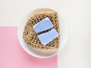 Homemade lavender soap bar and textile washcloth on minimalistic background. Set of plastic free and zero waste body care items.