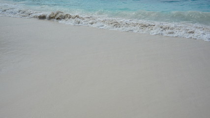 wave on a white sandy beach