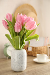 Composition with tulips in vase on wooden background, close up