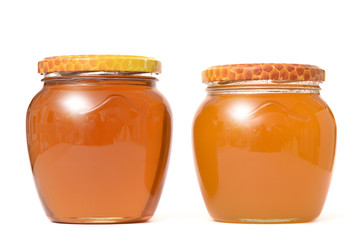 Two glass jars with fresh bright honey. The concept of healthy foods.