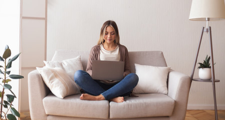 Young woman chatting with friend on laptop at home
