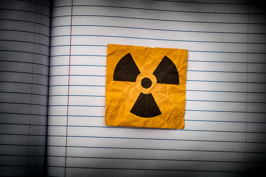 Radiation warning sign on a lined paper.